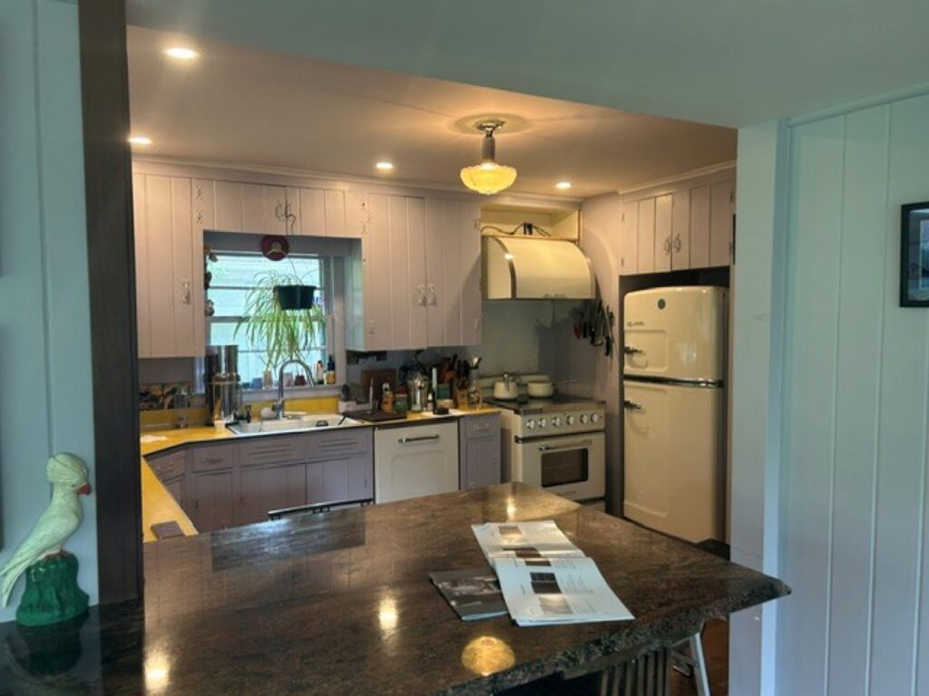 Dated cream kitchen with yellow laminate countertops before the Kitchen Express remodel